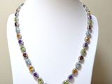 collier composé de perles de verre multicolores sur un mannequin blanc