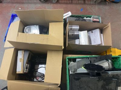 un tas d'appareils électroniques dans une boîte posée par terre