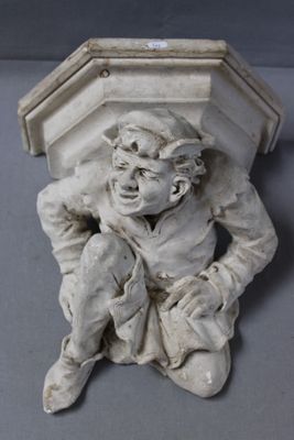 a small statue of a boy sitting on a ledge