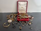 une boîte rouge remplie de nombreux bijoux, posée sur une table