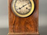 an image of a wooden clock on a stand on a gray background