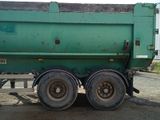 a green dump truck that is parked on the side of the road