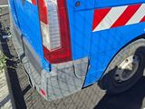 a blue van with red and white stripes parked on the side of the road