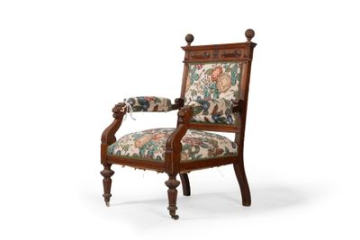 une chaise en bois dont le dossier et les accoudoirs sont recouverts d'un tissu à motifs floraux