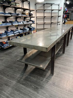 une longue table au milieu d'une pièce comportant de nombreuses étagères