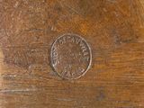 a penny on a wooden table that has been scratched off