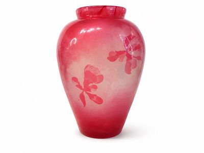 un vase rouge orné de fleurs roses sur fond blanc