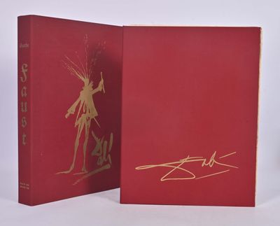 two red books with gold writing on them sitting on a white surface