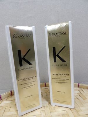 two bottles of kerastasee hair care sitting on top of a wooden table