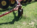 a tractor with a plow attached to it in the grass