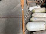 a lot of gas bottles and a wooden paddle on the ground