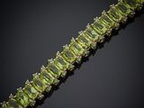 un gros plan d'un bracelet orné de pierres vertes sur fond noir