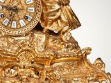 a gold clock that is sitting on top of a table