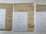 three old papers with writing on them sitting on top of a table