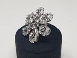 a close up of a diamond flower ring on a black ring box
