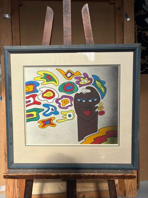tableau représentant la tête d'une femme aux cheveux colorés, posé sur un chevalet