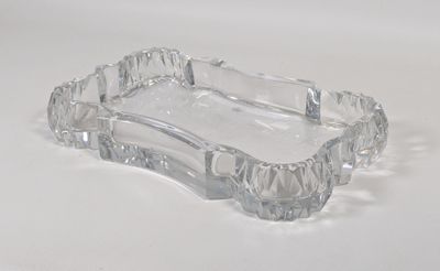 un cendrier en verre transparent posé sur une surface blanche