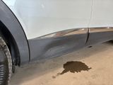 a puddle of water on the ground next to a car