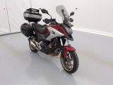 une moto rouge et blanche garée dans une pièce blanche