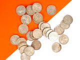 un tas de pièces d'argent sur un fond orange et blanc