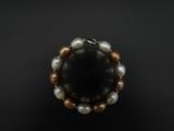 un gros plan d'un bracelet orné de perles sur un fond noir
