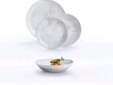 a white plate with a salad in it and a bowl with a carrot in it