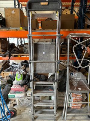 a man that is standing next to a cart in a warehouse