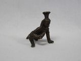 une vieille figurine en bronze représentant un homme assis sur une chaise