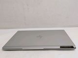 the back of a laptop computer sitting on top of a white table