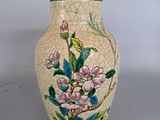 un vase orné d'un motif floral, posé sur une table
