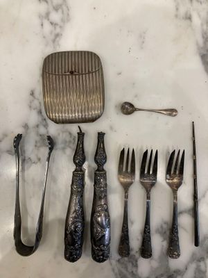 a lot of silverware on a marble counter top