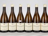 six bouteilles de vin sont alignées sur une table