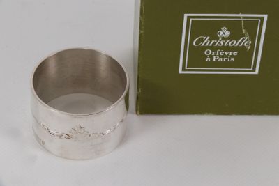 une bague en argent posée à côté d'une boîte verte sur une table