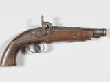 un vieux fusil exposé sur une surface blanche