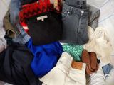 une pile de vêtements posée sur un lit