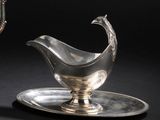 une assiette en argent sur laquelle repose une soucoupe en argent