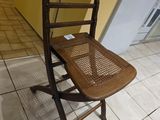 une chaise en bois posée sur un sol carrelé