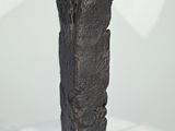 a black sculpture of a hand on a clear pedestal