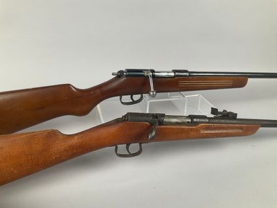 a couple of rifles sitting next to each other on top of a table
