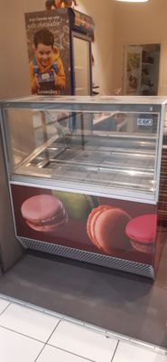 a display case with macarons on it in a store