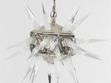 une lampe en cristal suspendue à une chaîne sur un mur blanc