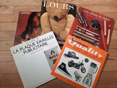trois livres posés sur la table, sur laquelle se trouve un ours en peluche