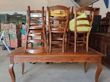 several chairs and a table in a room with a lot of furniture