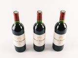 three bottles of wine sitting next to each other on a white surface