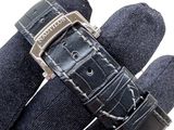 a black watch that is being held up by a glove