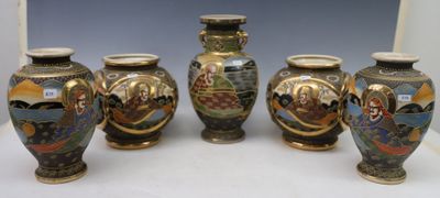 four vases with different designs are lined up on a table