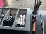 a tray with silverware and utensils on a table