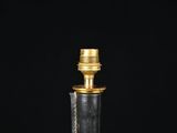 a close up of a black and gold bottle with a gold cap