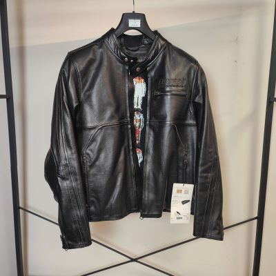 une veste en cuir noir suspendue à un portant dans un magasin de vêtements