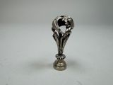 a silver figurine of a bird on a pedestal